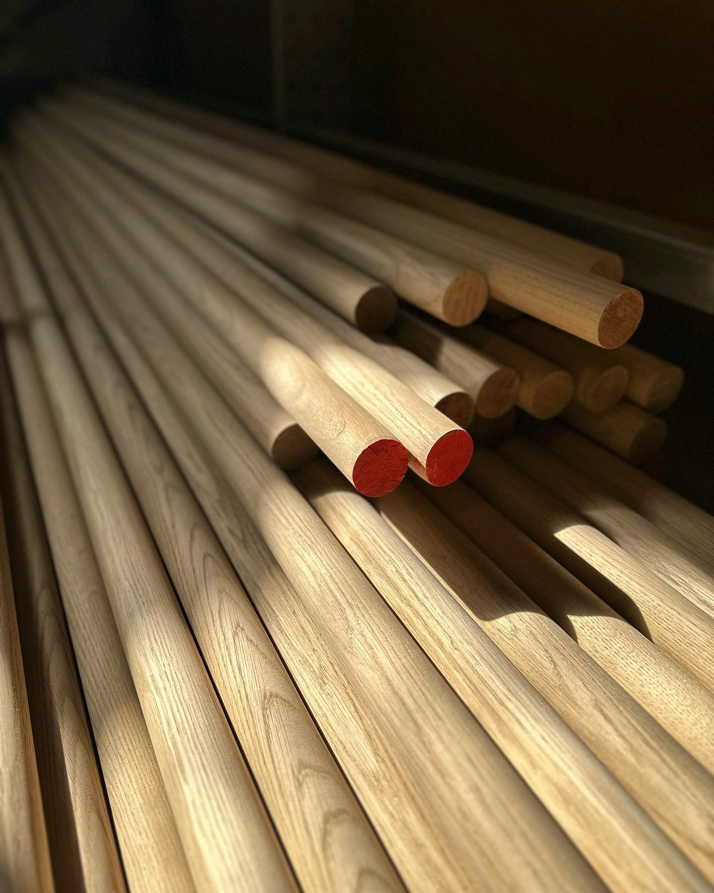 Long solid wood handrails and rods in workshop storage