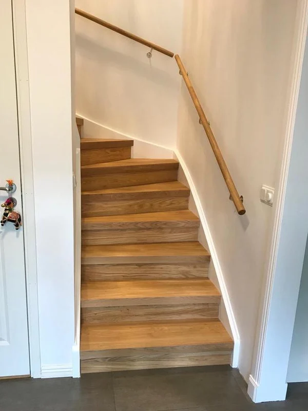 Oak stair handrail installed on an indoor staircase